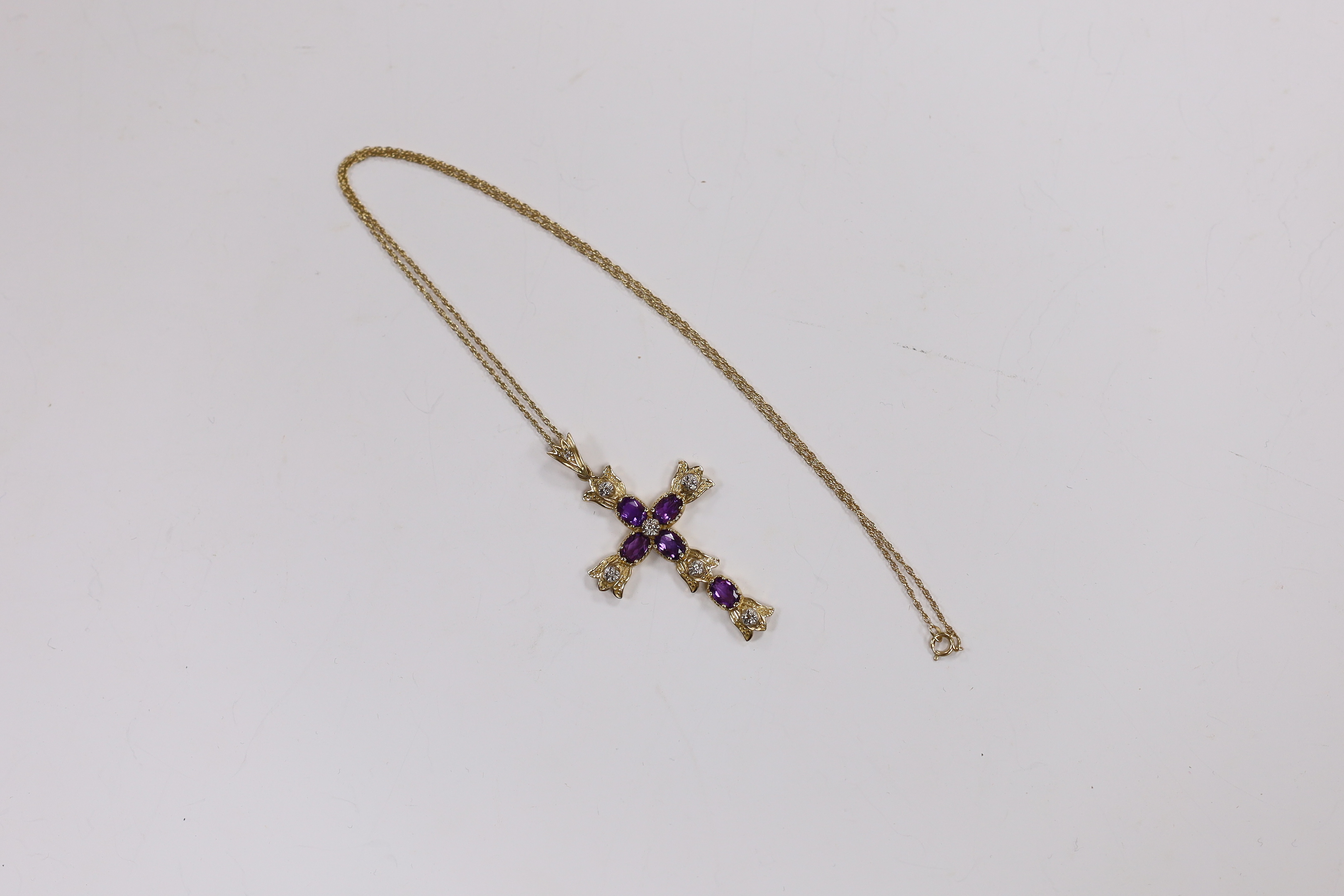 A modern 9k, amethyst and diamond cluster set cross pendant, 51mm, on a 585 yellow metal fine link chain, 45cm, gross weight 7.6 grams.
